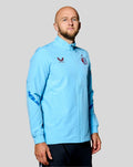 Man wearing a light blue Feyenoord third matchday jacket with full zipper chest logos and dark blue elbow prints