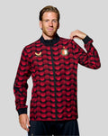 Man wearing Feyenoord home matchday jacket 2025-2026 with red and black polka dot pattern and gold logos