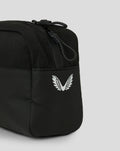 Close up of black Castore Toilettas showing a white wing emblem and braided zipper pull.