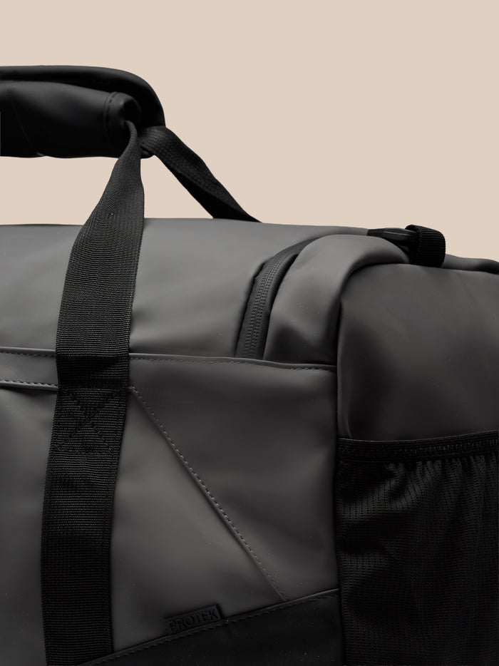 Close-up of the holdall strap and top edge showing durable black webbing and a padded carry handle.