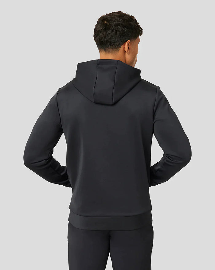 Back view of a person in a black hooded sweatshirt showing the hood and ribbed hem