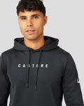 Close-up of a man in a black Active Flex hoodie with hood, chest Castore logo visible.