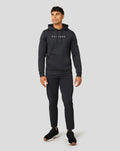 Full body shot of a man wearing a black Active Flex hoodie with hood and Castore branding.