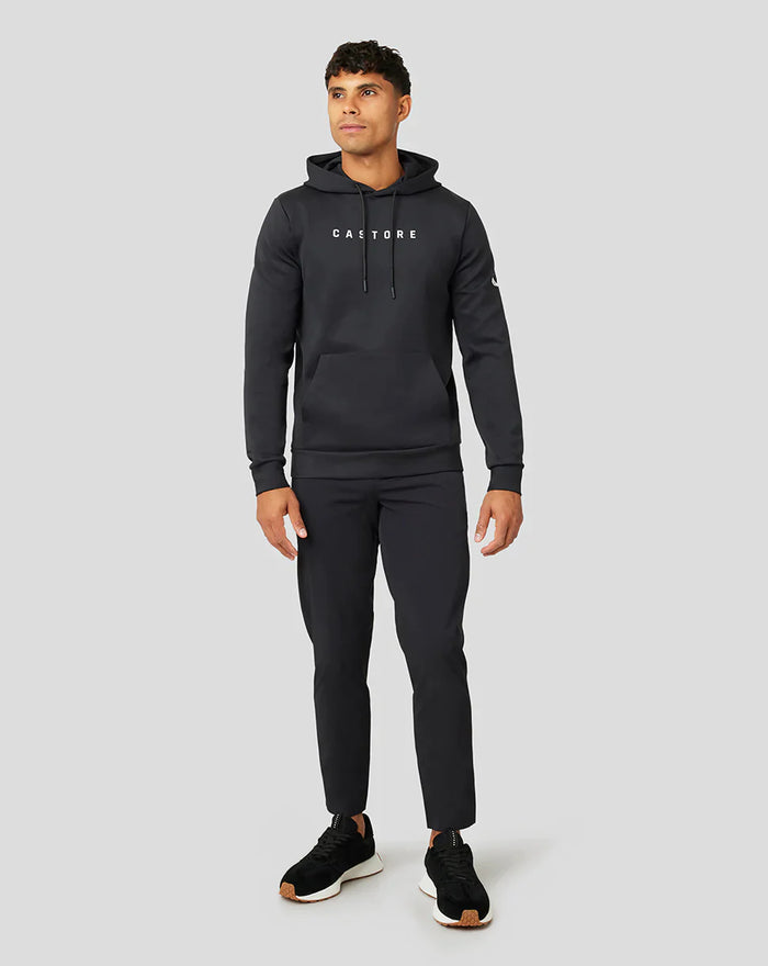Full body shot of a man wearing a black Active Flex hoodie with hood and Castore branding.