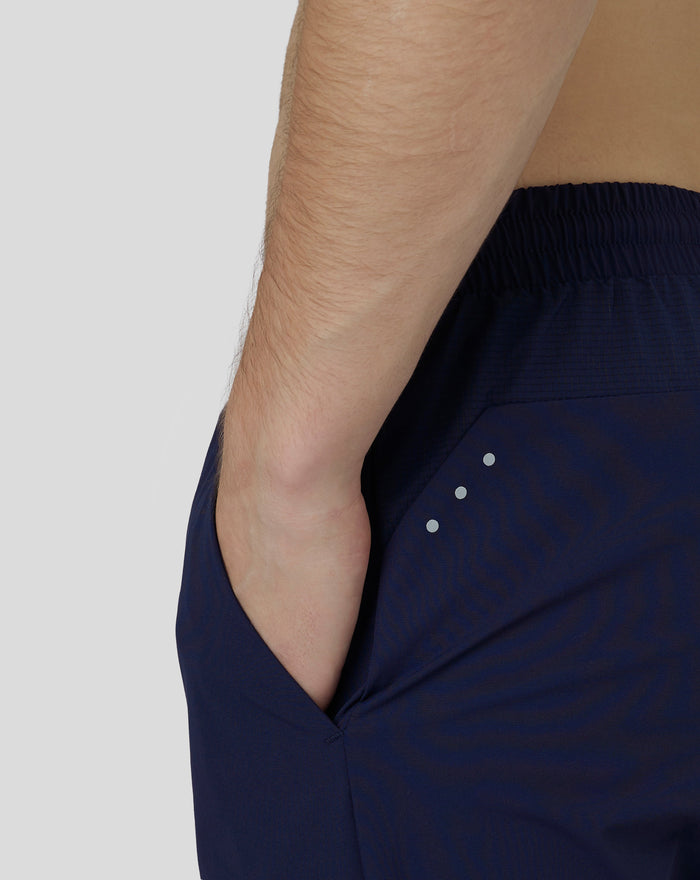 Close up of navy joggers showing hip area with reflective dots and seam details
