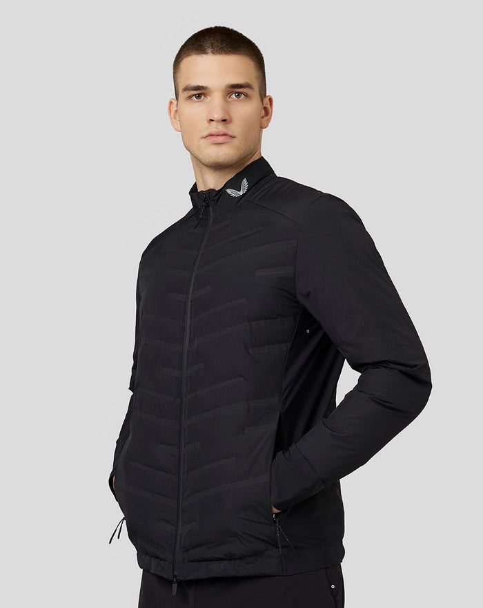 Front view of a man wearing a black Castore Zone Hybride Jacket with full zip and stand collar.