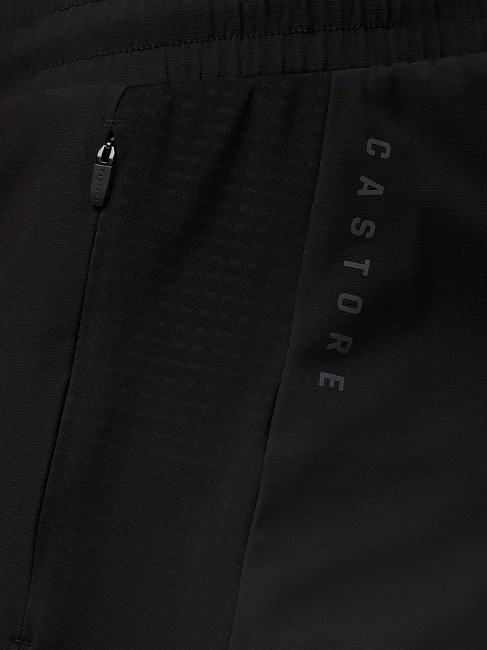 Close up of the waistband and side panel of black Apex Geweven Short showing Castore branding along the leg