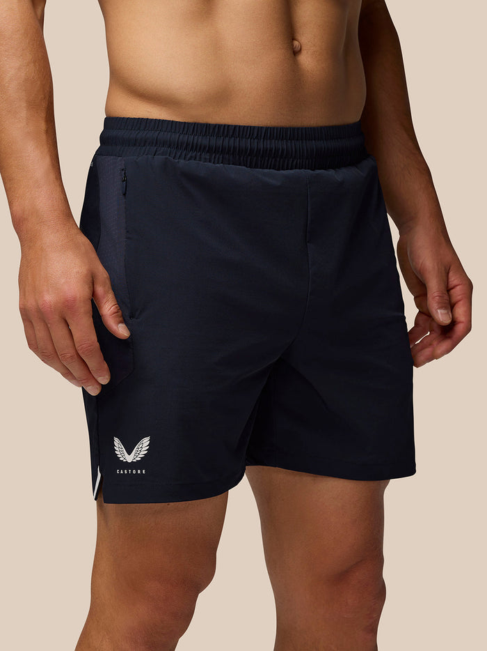 Side view of navy Aeromesh shorts with zip pocket and reflective Castore logos on the leg