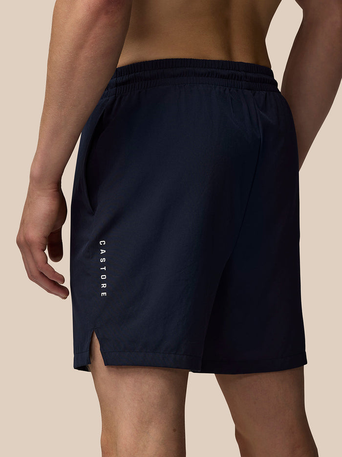 Back view of navy blue Adapt 6 inch Stretch woven shorts with elastic waistband and vertical Castore logo down the left leg.