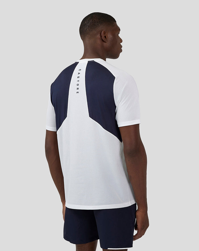 Back view of a male model wearing Apex Aeromesh T-Shirt in white with navy panels and a vertical Castore logo on the upper back