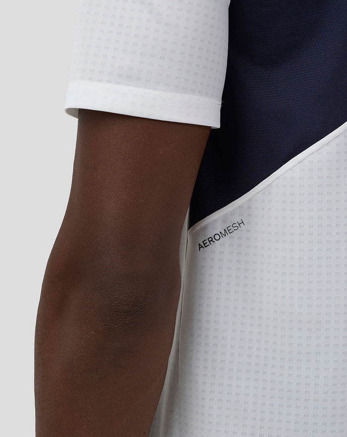 Close up of white Aeromesh fabric with perforated texture and Aeromesh branding along the sleeve area