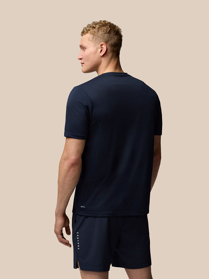 Male model in navy Adapt Short Sleeve Graphic T Shirt with matching shorts and Castore branding on the leg