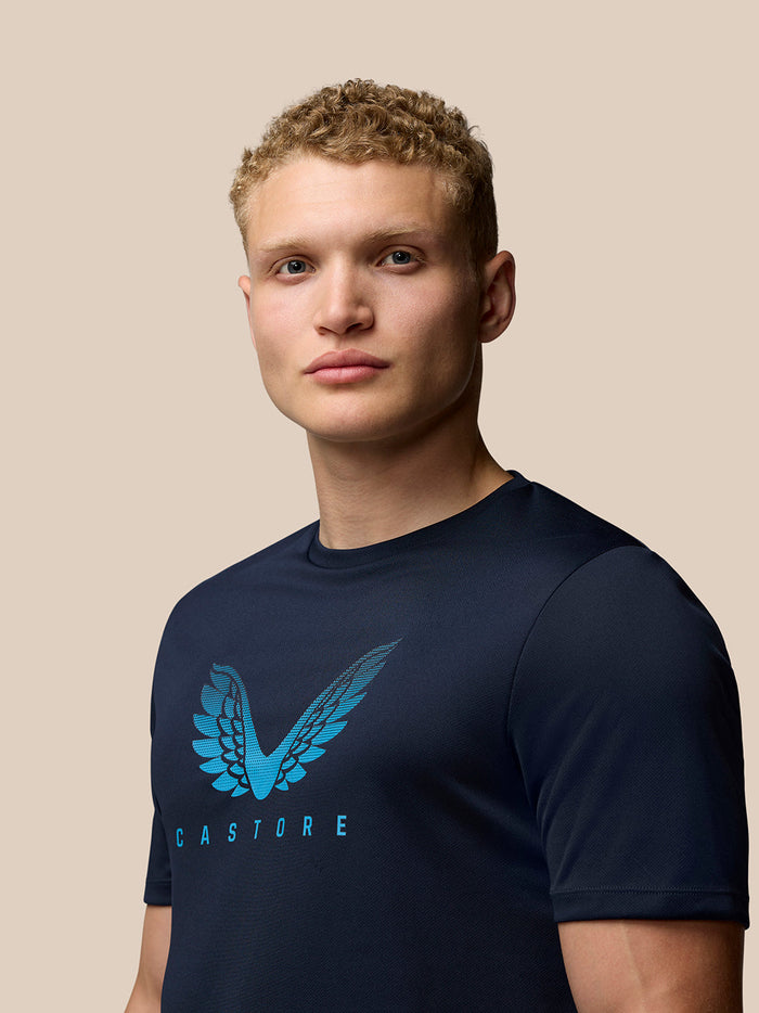Back view of male model in navy Adapt T shirt with Aertek logo at the hem and matching shorts with Castore branding
