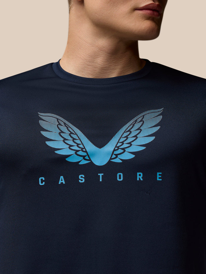 Herenmodel draagt marineblauw Adapt Graphic T-Shirt met blauw vleugellogo op de borst en CASTORE branding