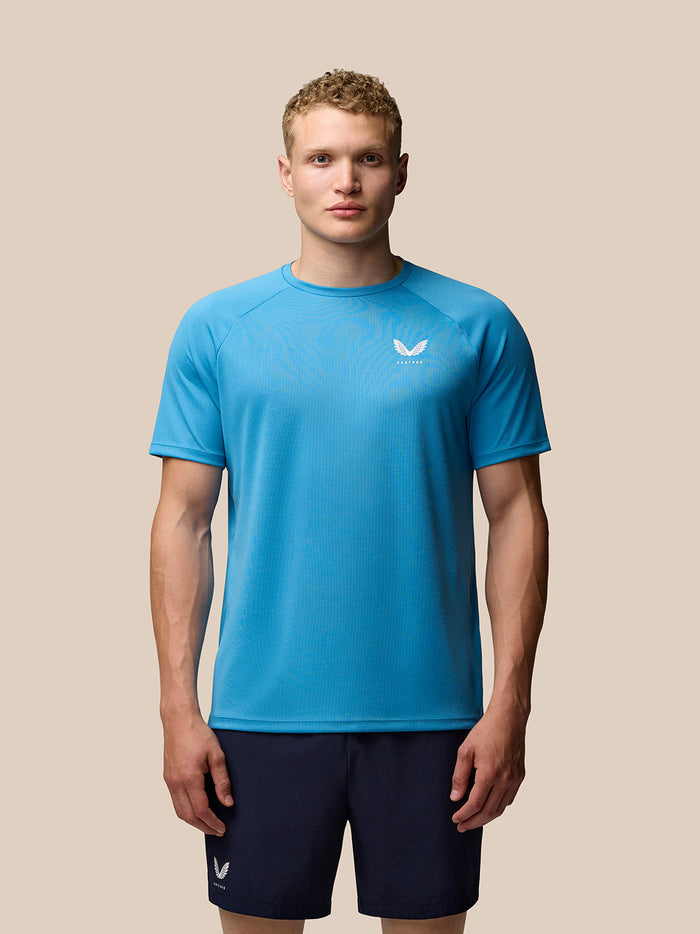 Front view of a male model wearing blue Adapt Short Sleeve T Shirt for men with Castore logo on the left chest and upper back