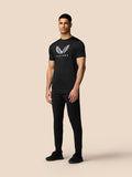 Male model wearing a black graphic training T shirt with a white wing emblem on the chest