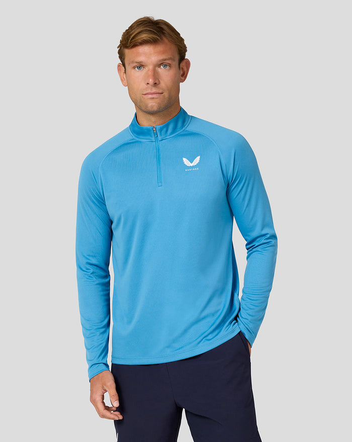 Male model wearing blue Adapt Long Sleeve Quarter Zip top with stand collar front view.