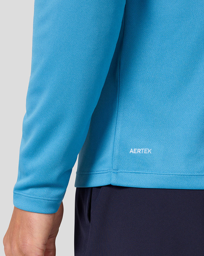 Close-up of the blue long sleeve top lower back hem with Aertek branding.
