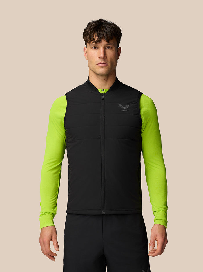 Front view of male model wearing black sleeveless gilet with neon lime sleeves and logo on chest