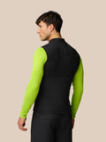 Back view of a man wearing black Apex Training Gilet with neon lime sleeves and vertical Castore branding along the spine.