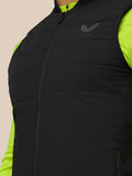 Close up of black padded gilet with Castore logo on left chest and bright neon green panel at neckline