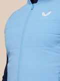 Close-up van lichtblauwe mouwloze Apex Training Gilet met centrale ritssluiting en wit Castore-logo op borst