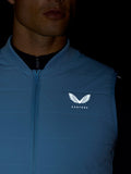 Portret van man die een lichtblauw Apex Training Gilet draagt met Castore-logo op borst