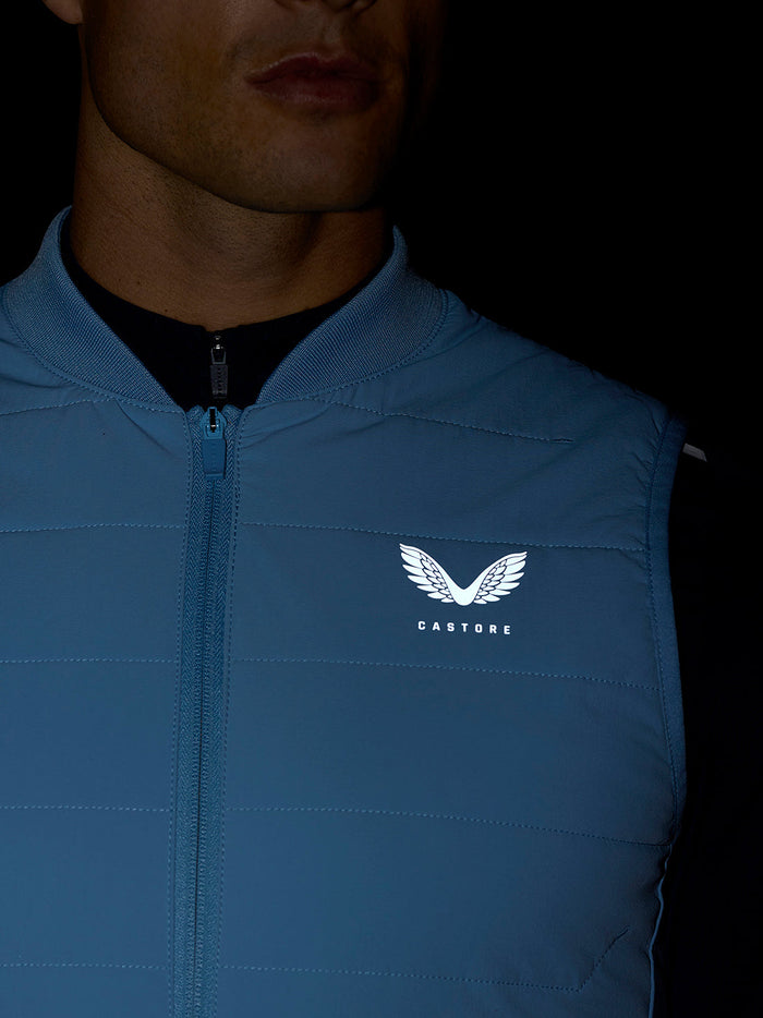 Portret van man die een lichtblauw Apex Training Gilet draagt met Castore-logo op borst