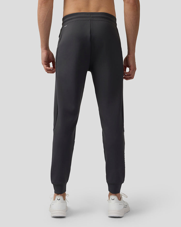 Back view of charcoal Scuba Lightweight Joggers with elastic waistband and cuffed ankles, paired with white sneakers