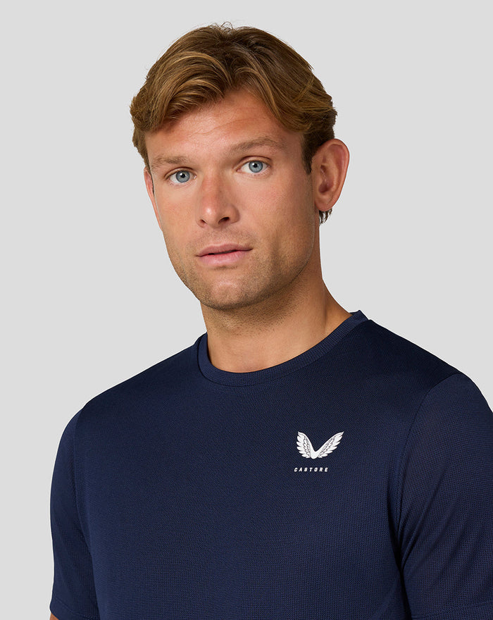 Front view of a man wearing the navy Apex Engineered Knit T Shirt with a small Castore logo on the chest.