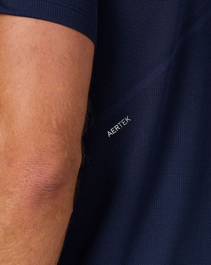 Close up of navy knit fabric showing the AERTEK branding on the sleeve area.