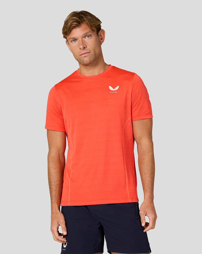 Front view of male model in coral Apex Geweven T Shirt Fiesta with navy shorts.