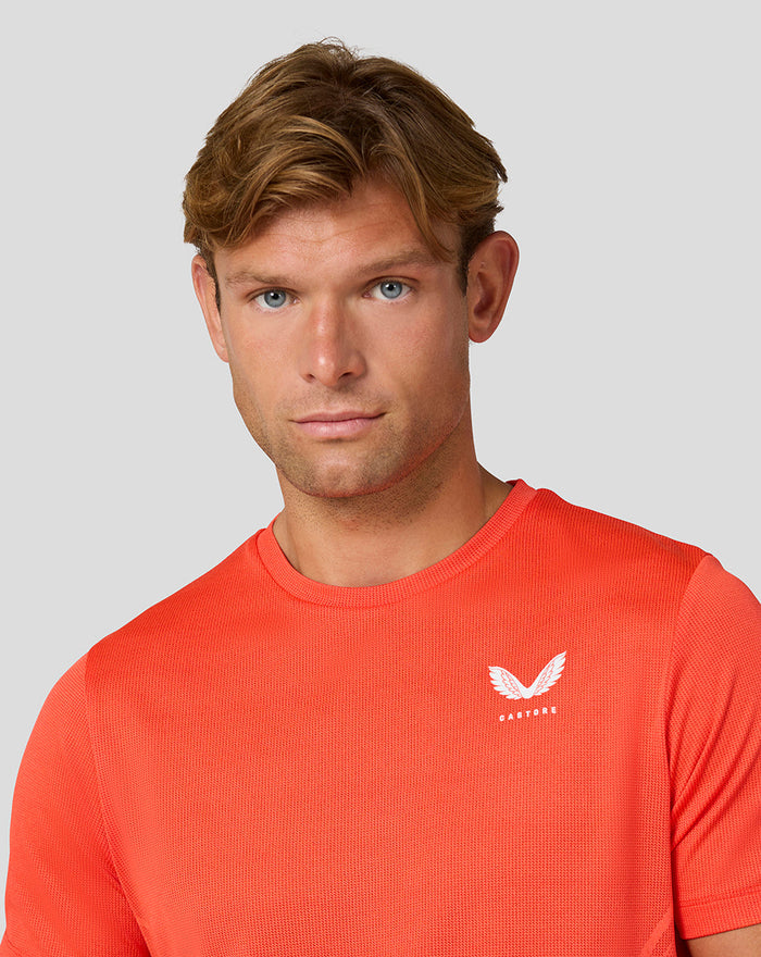 Front view of an orange Castore Apex T Shirt with a small white Castore logo on the left chest