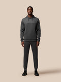 Full-body shot of a model wearing a dark gray Flex Lifestyle Hoodie with matching joggers