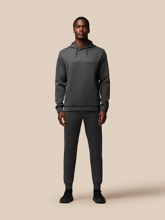 Full-body shot of a model wearing a dark gray Flex Lifestyle Hoodie with matching joggers