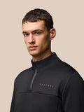 Back view of male model in black Flex Quarter Zip Top with high collar and Protek branding at the hem.