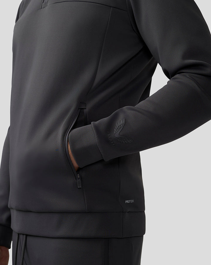 Close-up of a charcoal Scuba Quarter Zip Top showing a zip pocket and cuff with a logo