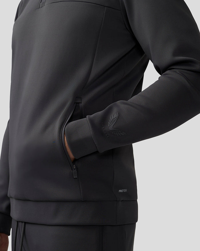 Close-up of a charcoal Scuba Quarter Zip Top showing a zip pocket and cuff with a logo