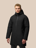 Male model wearing a long black hooded jacket with front zipper and zippered side pockets