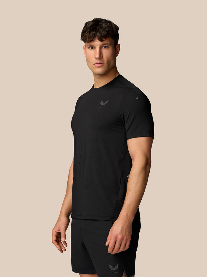 Side view of a man wearing black Apex Training T-Shirt and shorts with the Castore logo on the chest