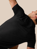 Side back view of man in black Apex Training T-Shirt during stretch with Castore branding visible on back