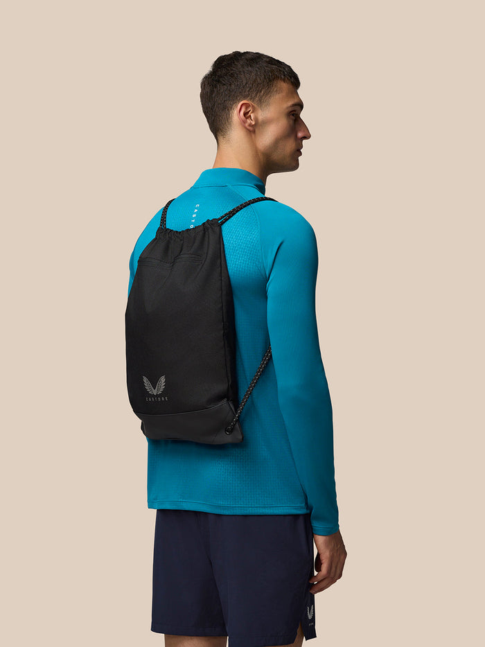 Man wearing a black Castore gym bag backpack with drawstring closure