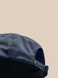 Close-up side view of navy cap showing strap buckle and Protek branding