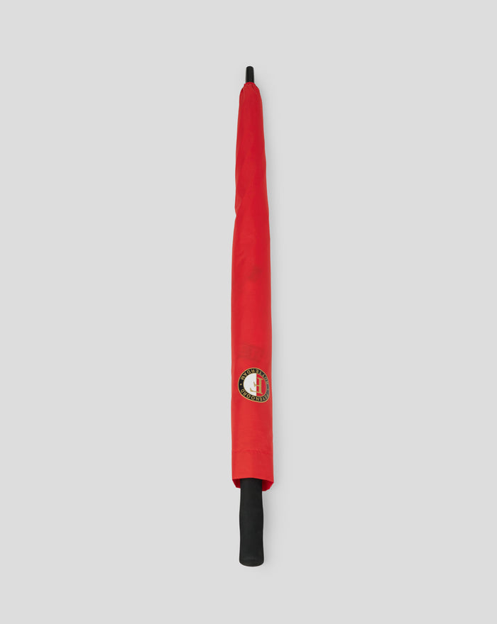 Closed red Feyenoord golf umbrella with logo on fabric and black shaft against a gray background.