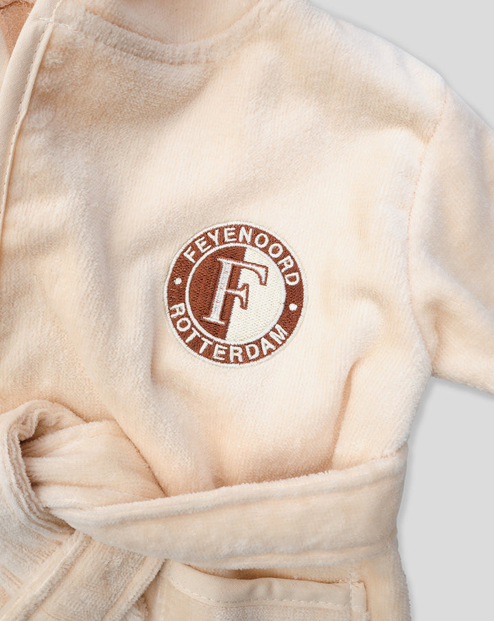Beige baby bathrobe with a circular Feyenoord Rotterdam logo on the chest.