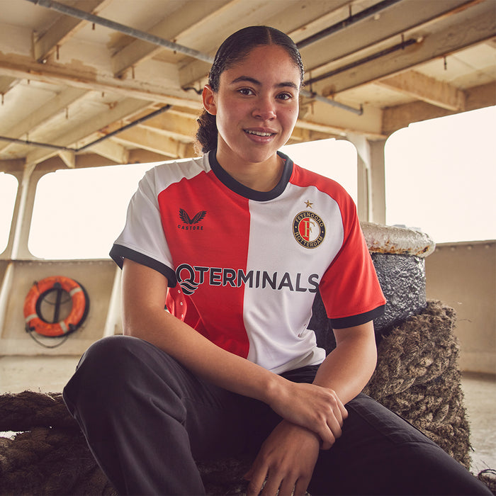 Meisje draagt Feyenoord thuisshirt met rood en wit blokdesign en golvende print op voor- en achterkant