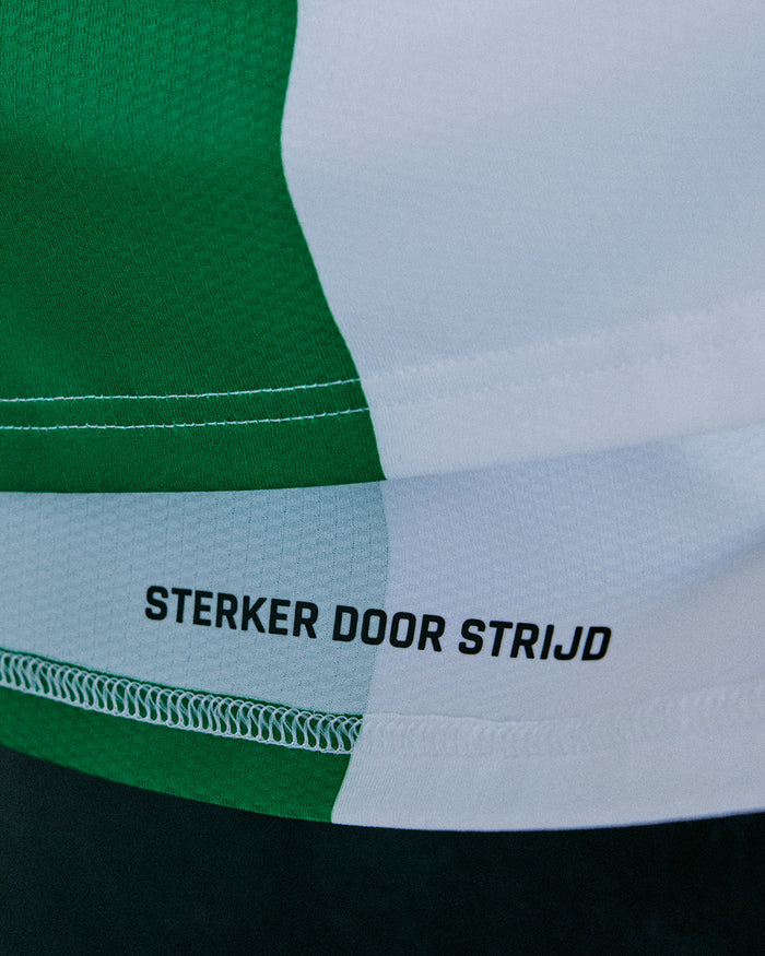 Lower hem close-up of the Feyenoord Pro Derde Shirt with a green panel and Sterker Door Strijd slogan.