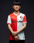 Man draagt Feyenoord thuisshirt 2025-2026 mannen met rode en witte banen en sponsorlogo