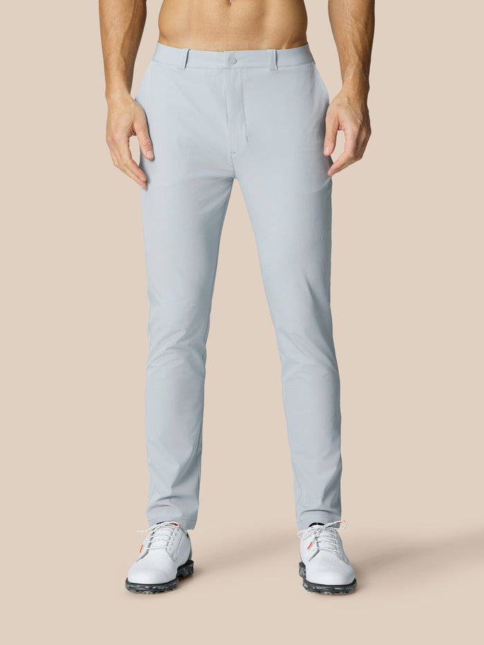 Vooraanzicht van een man die lichtgrijze Club Golfbroek draagt met witte golfschoenen.