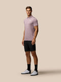 Model draagt zwarte Golf Lichtgewicht Short en roze polo, toont pasvorm en zakken.